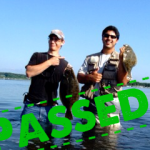 two guys wading in salt marsh with flounder